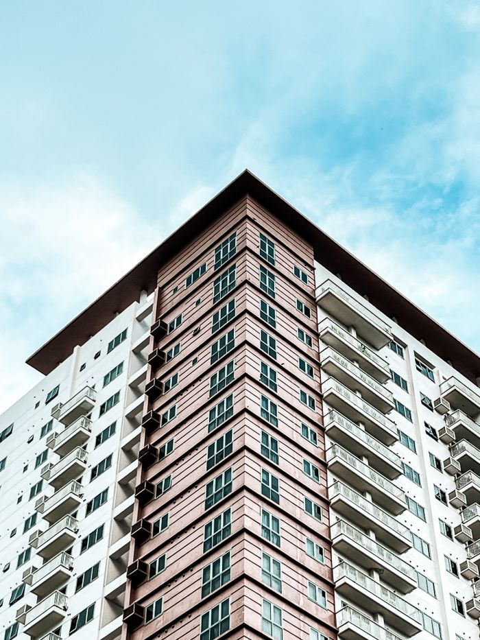 High angle view of a modern condominium building with a blue sky background.