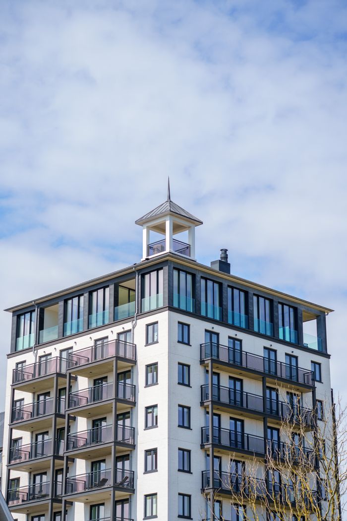 Elegant modern apartment building against blue skies in Cadzand, Zeeland, Netherlands.