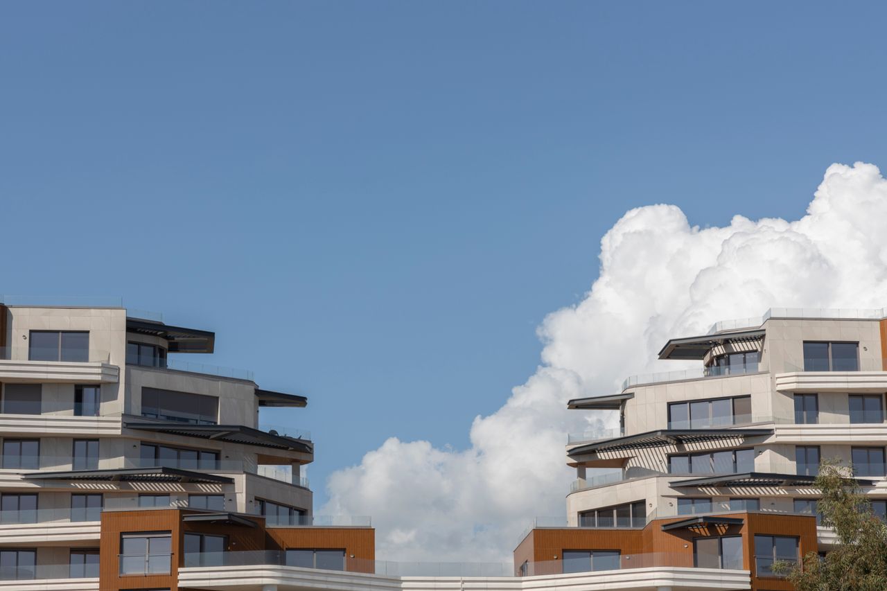 Contemporary urban architecture under a bright blue sky with clouds.